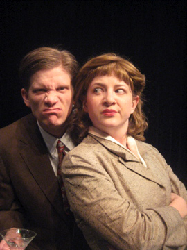 Closeup of two people dressed in 1940s garb scrunch their faces at the camera.