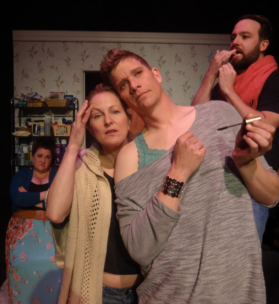 Two people stare into the mirror. Together they contemplate their eyebrows. Someone is flossing their teeth in the background.