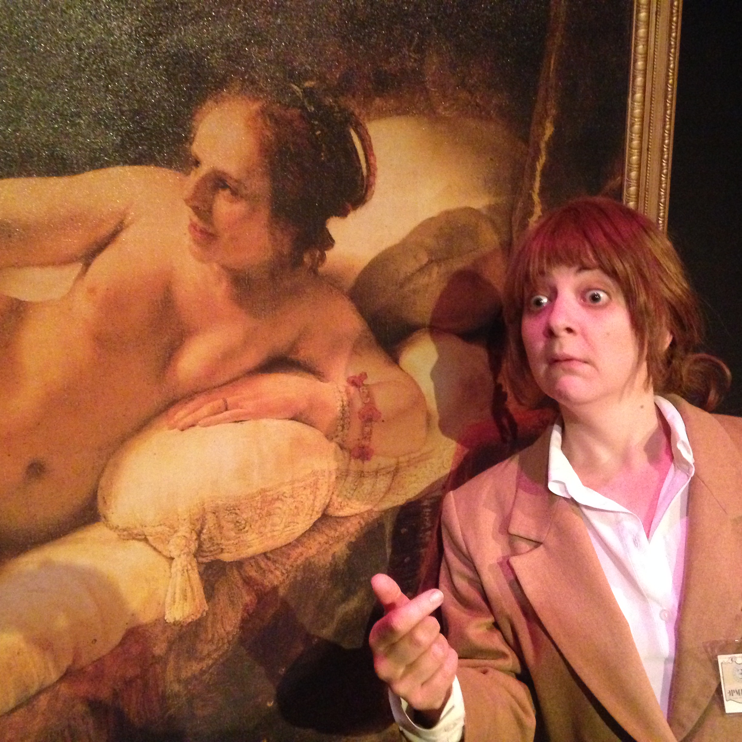 A female art museum security guard stands next to Rembrandt’s painting of Danae. The picture is a close up so we can clearly see both Danae’ face and the museum guards.