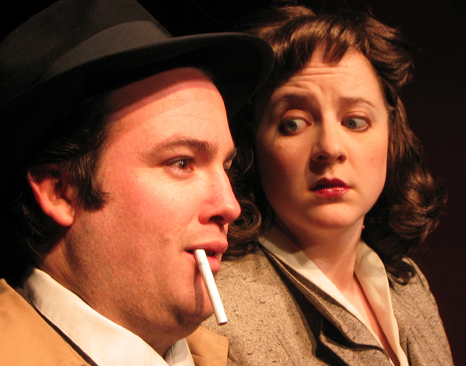 Close up of two 1940’s. The man with a cigarette dangling from his lips and the woman looking at him with big eyes.