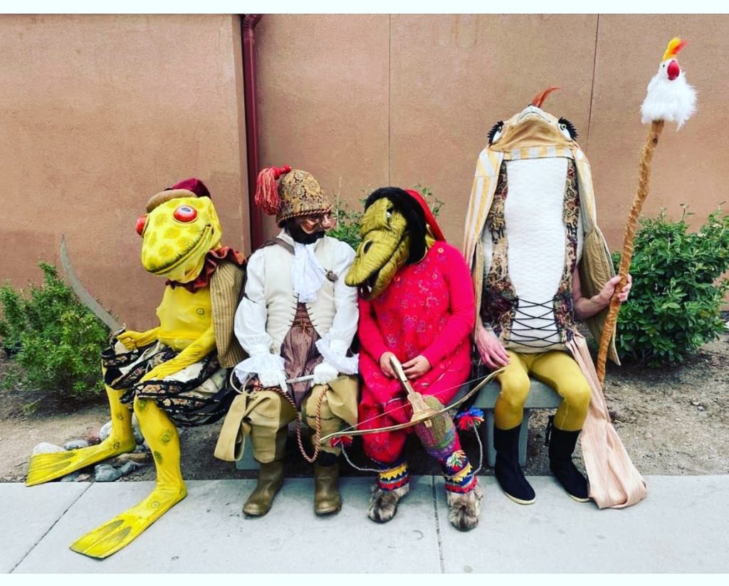 4 fantastical creatures sit on a bench together.