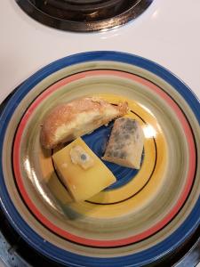 3 moldy pieces of cheese on a fiestaware plate. 