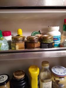 Inside a fridge door, 2 shelves with many jars.