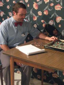 A man sits at a table doing a jigsaw puzzle.