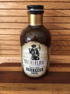 A bottle of Barbecue Sauce with a wooden backdrop. 