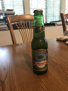 A green bottle of beer on a wooden table. 