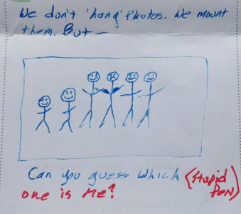A line drawing in blue ink of a group of six stick figures. They are all smiling, except for one that appears to have flexed arm muscles. Around the drawing it says “We don't hang pictures. We mount them. But can you guess which one is me?