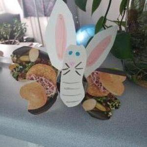 Butterrabbit/rabbitfly- A rabbit-looking creature cut out of white paper has colorful butterfly wings made from paper printed with images of food.