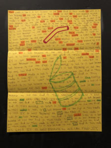 On a bright yellow piece of paper is a drawing of a green can with a red noodle above it. Written across the entire page is a long story about the lost and lonely noodle. Some of the words are highlit.