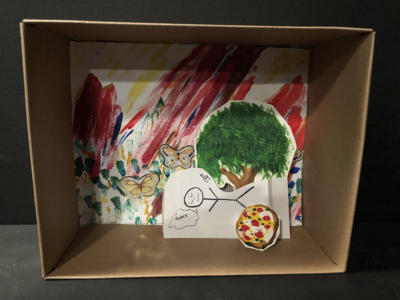 A diorama in a small cardboard box. The background is colorful and squiggly with butterfly stickers. In front there is a painted tree. Under the tree is a passed out stick figure, snoring. Next to them is a cutout painting of a pizza.