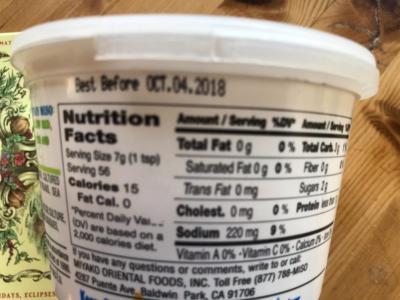 Close-up of the nutrition facts on a white plastic container. The “best before” date is October 4th 2018.
