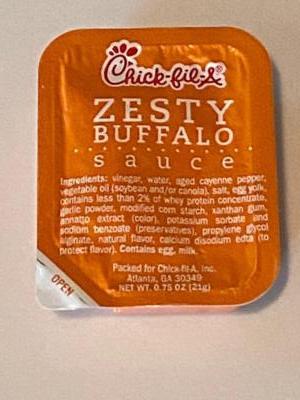 Close-up shot of a packet of Chick-fil-A Zesty Buffalo Sauce.Sorry it’s not funny or gross.  But neither of us can honestly remember the last time we went to this place!! 