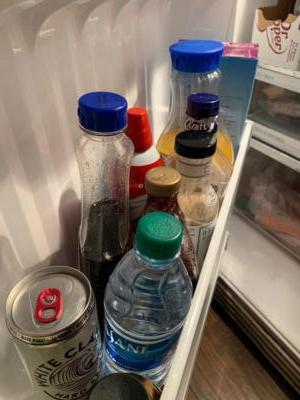 Picture of the inside of a refrigerator door. Various cans, jars, and bottles fill the shelf.Generic brand syrup expired March 2019. Yum!